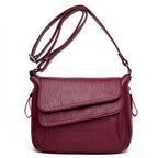 Burgundy soft leather crossbody bag with an adjustable strap, front flap pocket, and silver-tone hardware.