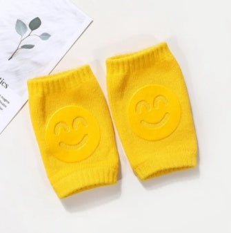 Bright yellow baby terry knee pads with a raised, matching yellow smiley face design for crawling comfort.