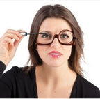 Woman applying mascara while wearing brown, flip-down single-lens makeup reading glasses.