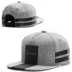 Grey jersey baseball cap with black paneling, "TRES SLICK" text, and black dual-stripe detail. Adjustable snapback.