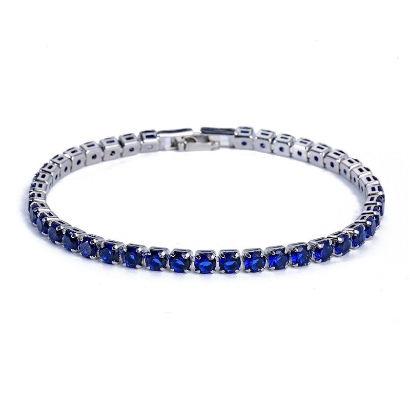 Silver-tone tennis bracelet featuring a row of micro-inlaid round blue zircon stones with a secure metal clasp.