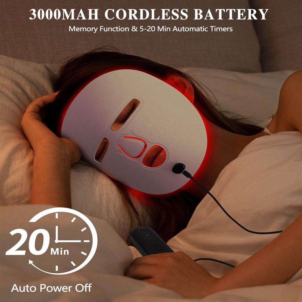 Person wearing a white LED red light therapy facial mask while lying in bed, connected to a handheld power controller.