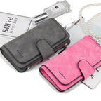 Grey and pink faux suede bi-fold wallets with snap closures and zipper detailing, displayed on a flat lay.