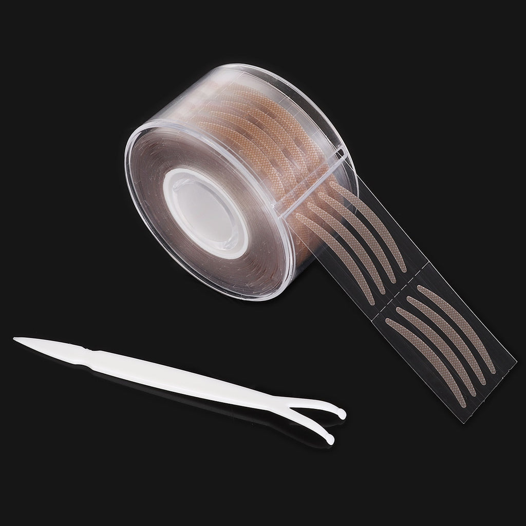 Roll of beige adhesive double-fold eyelid stickers with a white applicator tool on a black background.