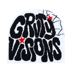 White knit beanie with black "GRTY VISONS" graffiti text, red star accents, and black spiderweb graphic on the side.