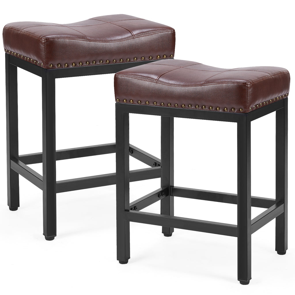 Two brown faux leather saddle bar stools with black steel frames and decorative brass nailhead trim.