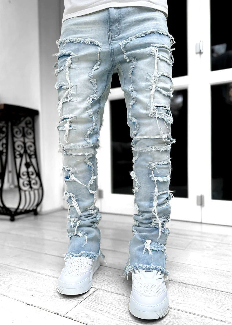 Light blue, stacked, distressed denim jeans featuring raw-edge patches, ripped details, and a tight, fitted cut.