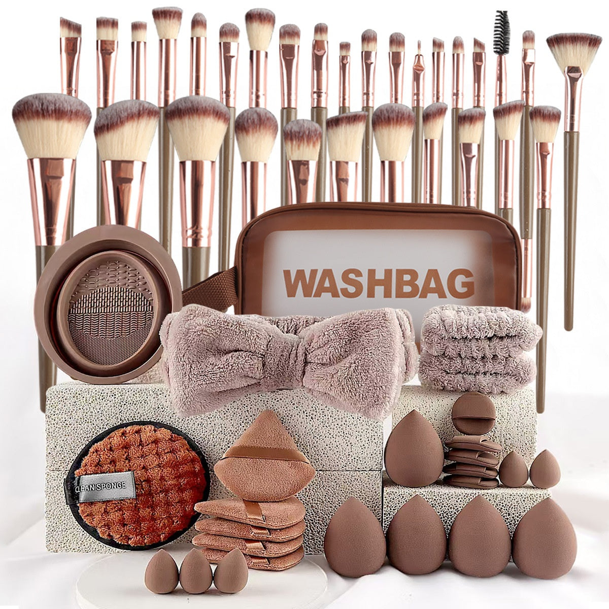 Makeup brush set with rose-gold ferrules, brown handles, washbag, plush headband, cleaning tool, and various sponges.