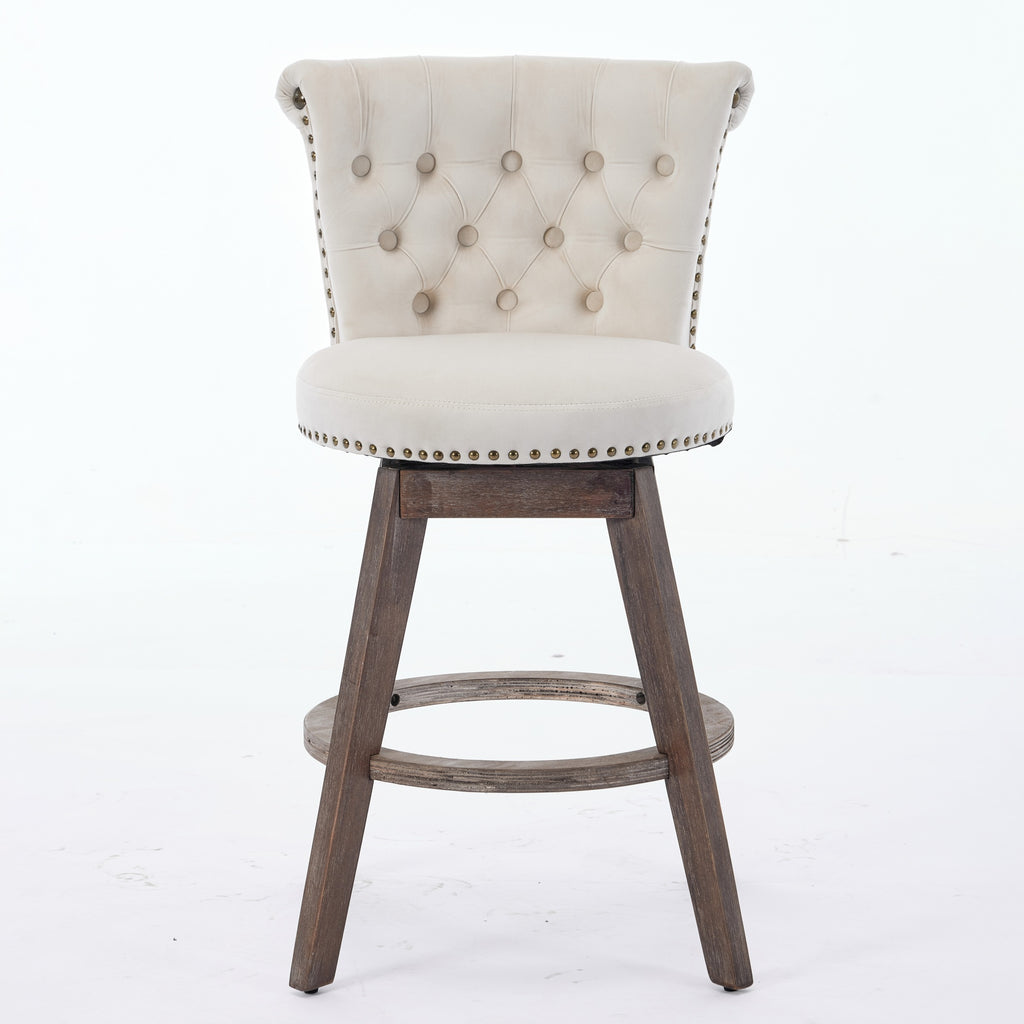 Beige tufted velvet swivel bar stool with nailhead trim and brown wooden legs on a white background.