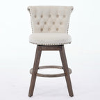 Beige tufted velvet swivel bar stool with nailhead trim and brown wooden legs on a white background.