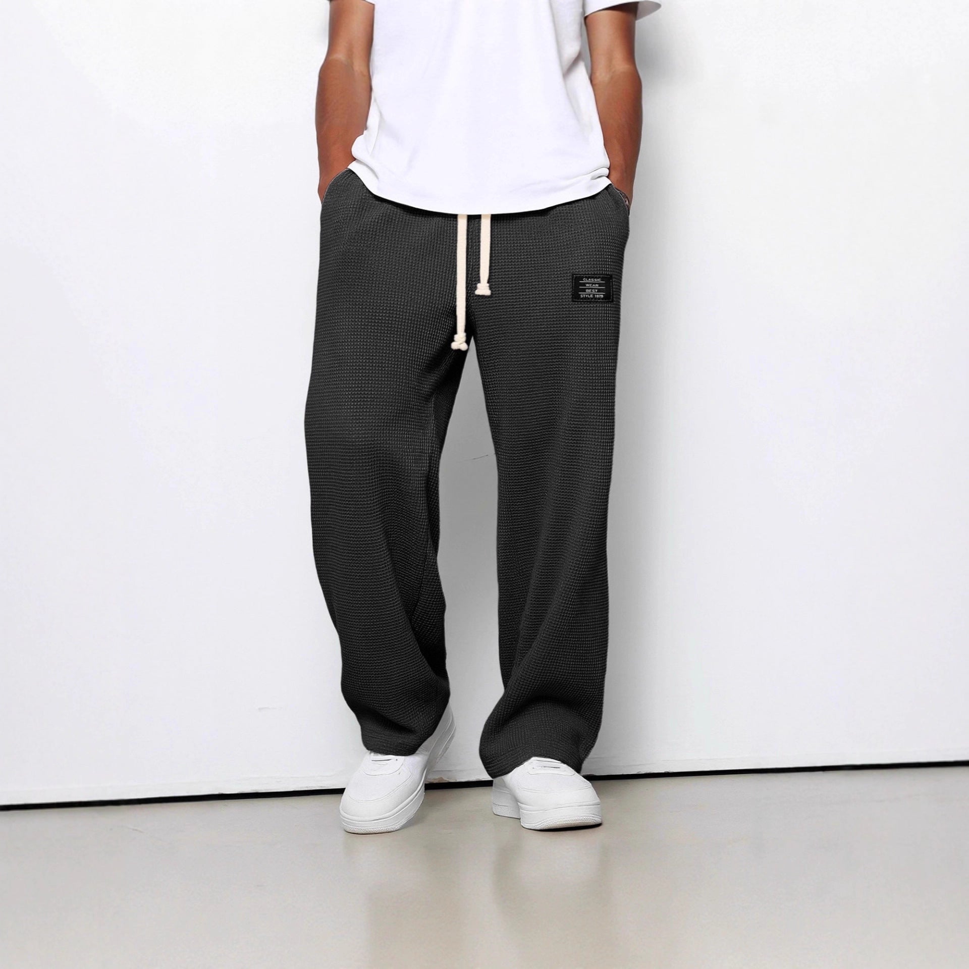Charcoal grey waffle-knit straight pants featuring an elastic drawstring waist and small logo patch.