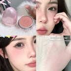 Pink egg-shaped blush compact featuring a low-saturation gray-toned powder with an embossed swirling face design.