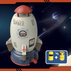White rocket sprinkler toy with orange top, astronaut bear graphic, and blue base, includes yellow hose connectors.