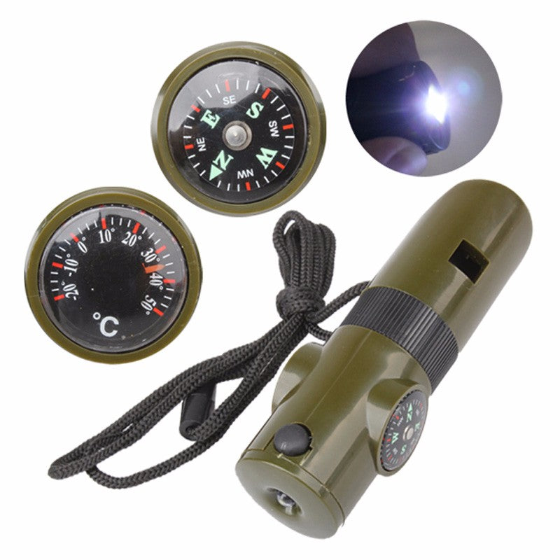 Olive green 7-in-1 survival whistle with compass, thermometer, and LED light on a black lanyard against white background.