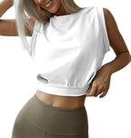 A woman wears a white, sleeveless, loose-fitting cropped sweatshirt with a crew neck, paired with olive-green leggings.