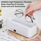 A white, rectangular ultrasonic glasses cleaner with a red power switch on a woven mat, with text about 45000Hz cleaning.
