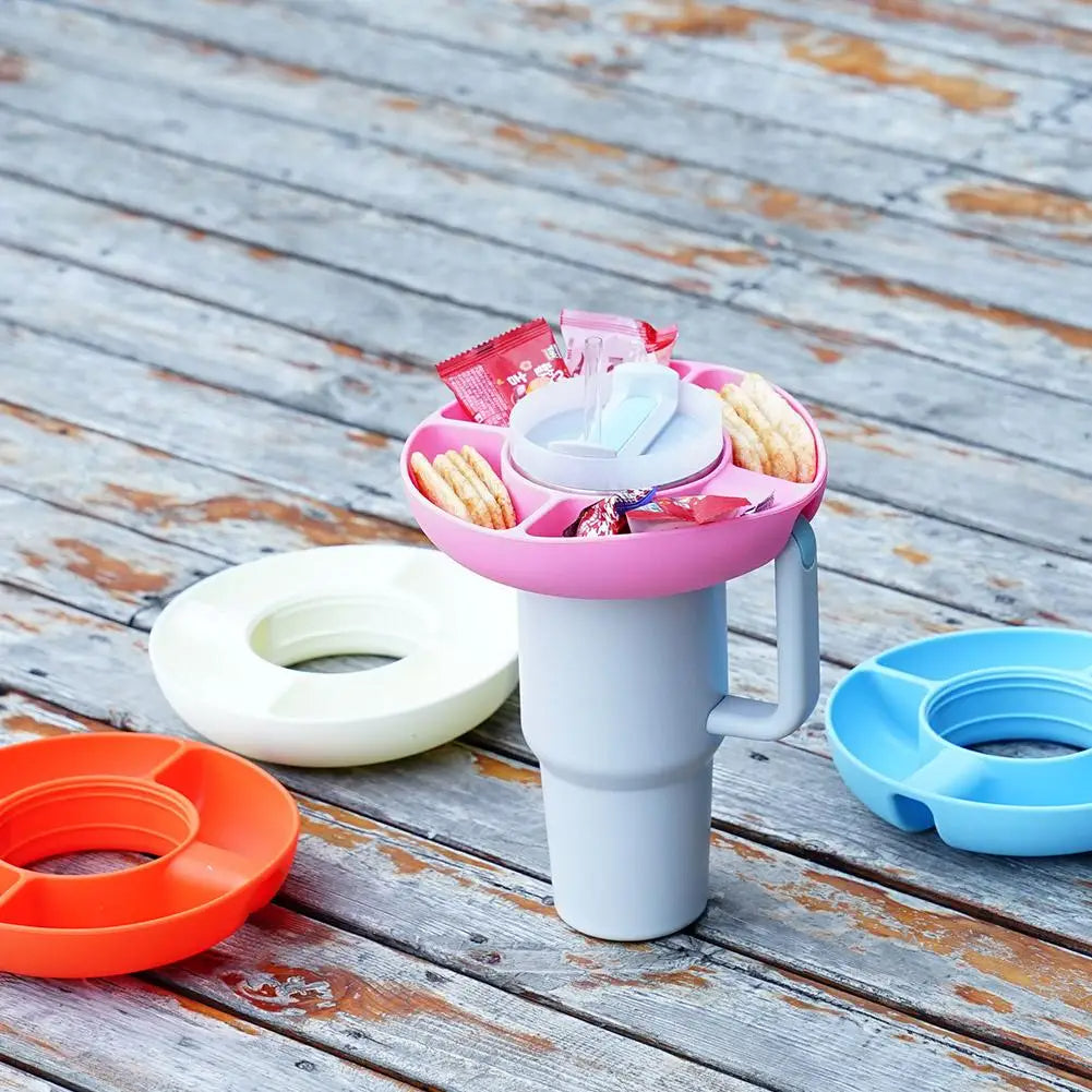Pink silicone snack tray with 4 compartments on a 40oz tumbler, surrounded by orange, white, and blue snack ring options.