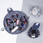 Three drawstring cosmetic bags, one open and two closed, featuring floral and patterned fabric in gray and navy.