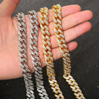 Four gold and silver-toned chunky cuban link bracelets paved with sparkling crystals held in a hand.