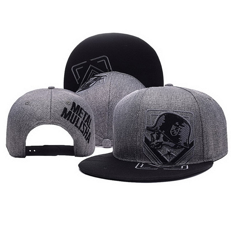Grey and black Metal Mulisha snapback hats featuring skull-in-helmet embroidery and structured flat brims.