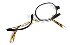 Black makeup reading glasses with a single flip lens and leopard print temples on a white background.