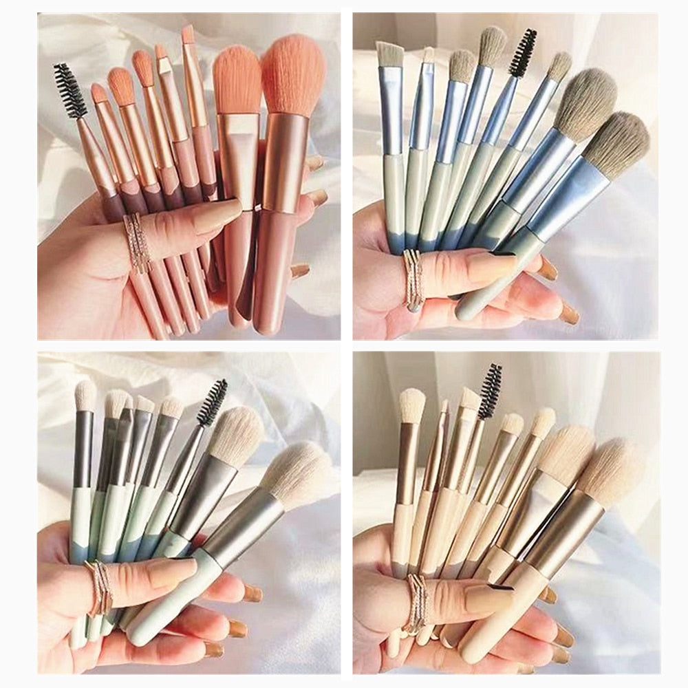 Four sets of 8 portable makeup brushes with metallic handles in pink, blue, sage, and beige, held in a hand.