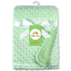 Mint green baby blanket with raised dots, wrapped in white ribbon with a Kolaco brand tag. Soft textured fabric.