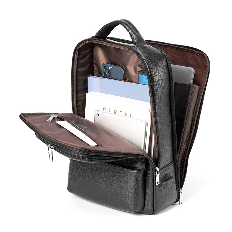 Black leather multifunctional backpack with USB port, opened to show brown interior, laptop sleeve, and storage pockets.