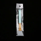 A silicone face mask brush with a light blue handle and gold ferrule, sealed in a clear plastic retail bag.