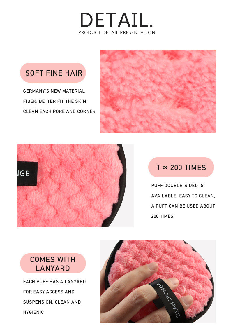 Pink circular makeup puff with soft, textured fiber, black trim, and finger-strap lanyard. Reusable and gentle.