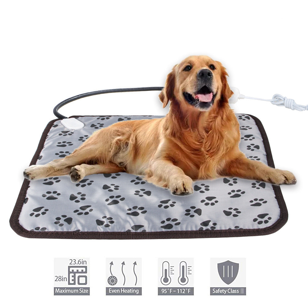 A golden retriever rests on a gray pet heating pad with paw print patterns, a brown border, and a chew-resistant cord.