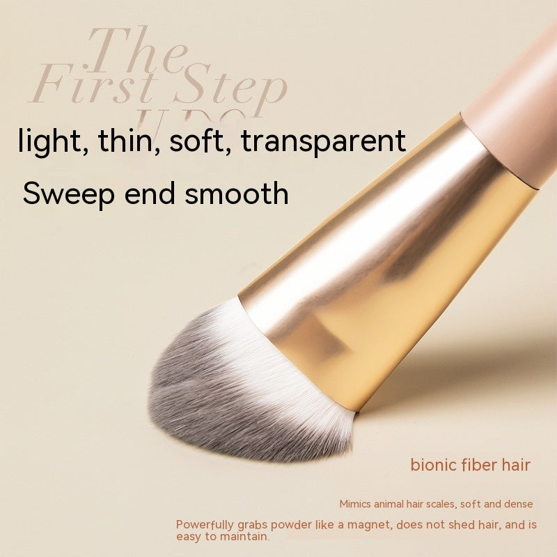 Soft flat-head makeup brush with metallic gold ferrule, bionic fiber bristles, and text overlay on a beige background.