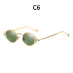 Vintage gold-tone steampunk sunglasses with oval green lenses, intricate frame engravings, and ornate metal temple arms.