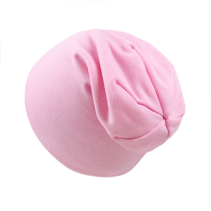 Soft, light pink newborn baby beanie made of smooth, stretchy jersey fabric with a classic rounded fit.