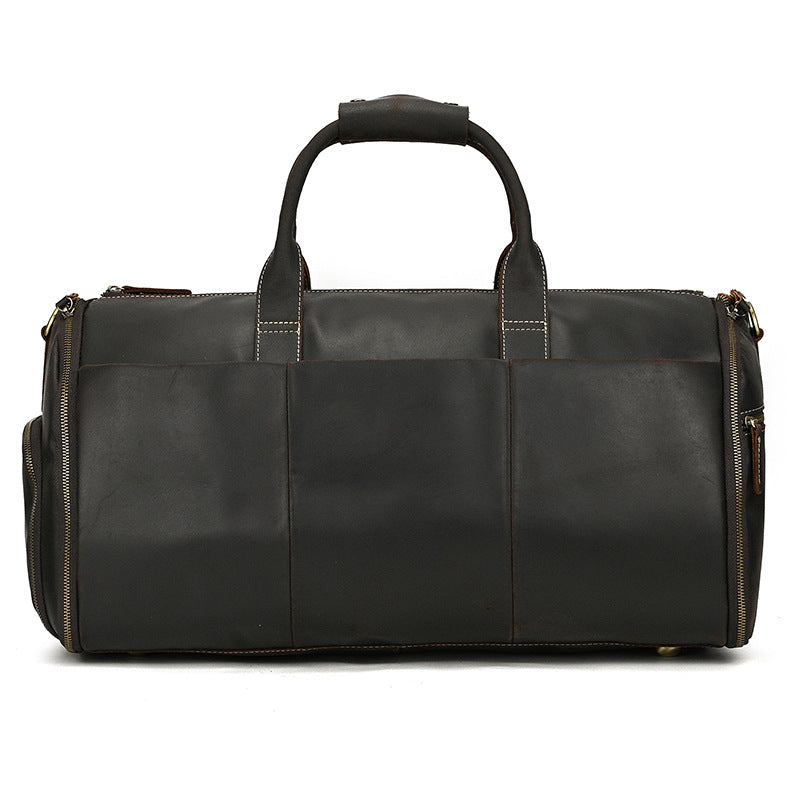 Vintage brown leather duffle bag with sturdy top handles, side zippers, and minimalist design on a white background.