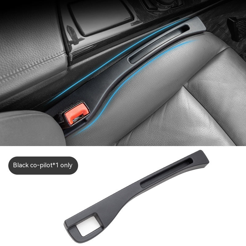 Black matte plastic car seat gap organizer inserted between the console and leather seat. Includes seat belt slot.