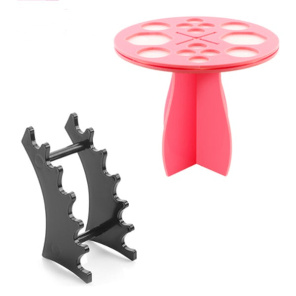 Pink 14-hole round makeup brush drying rack and a black multi-slot brush display stand on a white background.