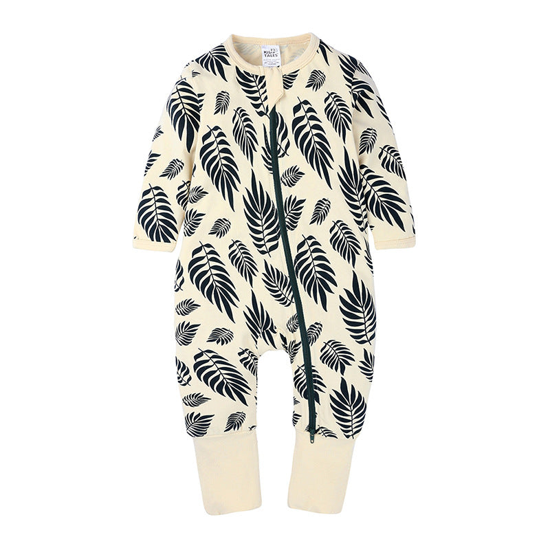 Cream-colored baby cotton onesie with a black leaf print, featuring long sleeves and a full-length front zipper.