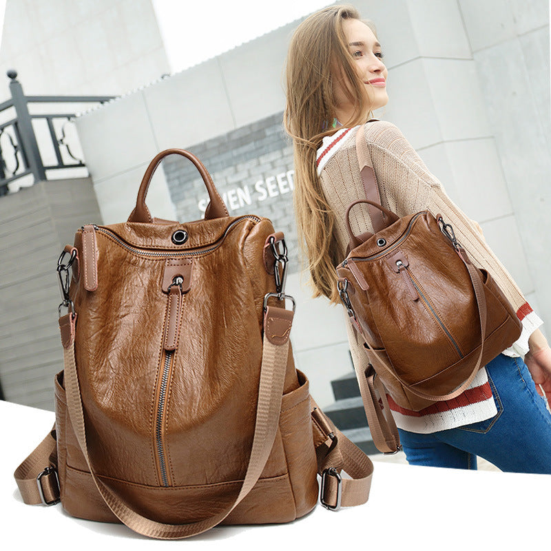 Brown soft leather multifunctional backpack with vertical front zipper, top handle, and adjustable shoulder straps.