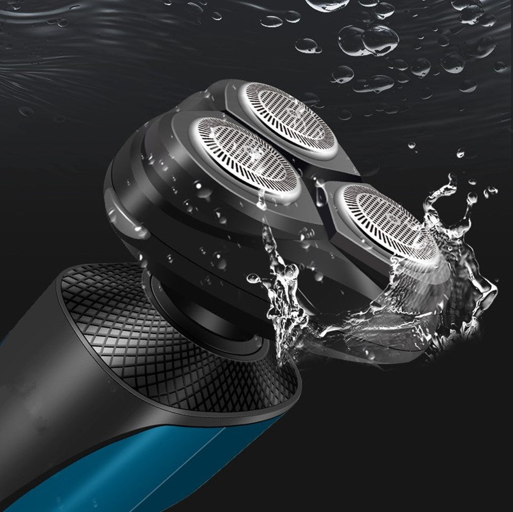 Black and blue electric rotary shaver head with three metal blades, shown underwater with splashing water droplets.