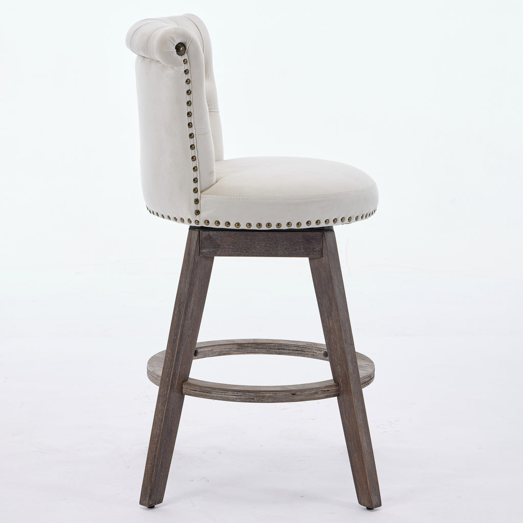 Beige tufted velvet swivel bar stool with nailhead trim and brown wooden legs on a white background.