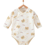 Cream-colored cotton baby romper with a cute bear and "cute" text pattern, featuring a side-snap closure.