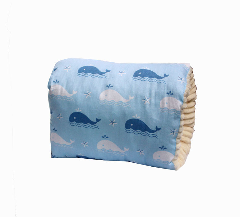 Light blue cotton nursing arm pillow featuring a whale pattern with a soft, cream-colored ribbed underside.