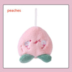 Soft, fuzzy pink plush peach hand warmer with embroidered face, green leaves at base, and a hanging white loop.