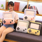 Woman holding a plush, pastel-colored retro gaming console pillow with a clear hand-warming sleeve feature.