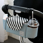 Light blue fabric baby stroller organizer with black and white striped flap, side cup holders, and Velcro straps.