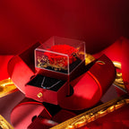 Red apple-shaped gift box with a preserved red rose under glass and a sliding drawer containing a delicate necklace.