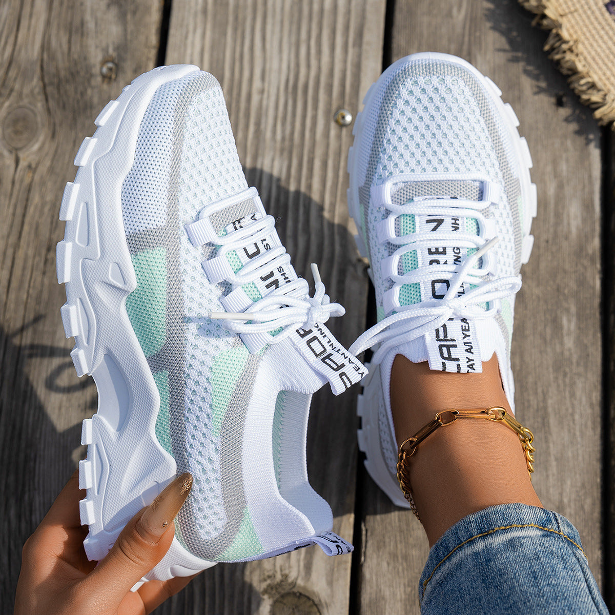 White breathable mesh sneakers with gray and mint green accents, chunky white soles, and branded lace-up design.