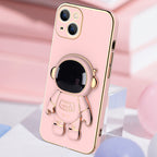 Pink phone case with a shiny gold trim and a 3D astronaut figure that serves as a kickstand bracket.