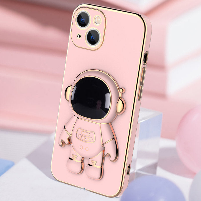 Pink phone case with a shiny gold trim and a 3D astronaut figure that serves as a kickstand bracket.
